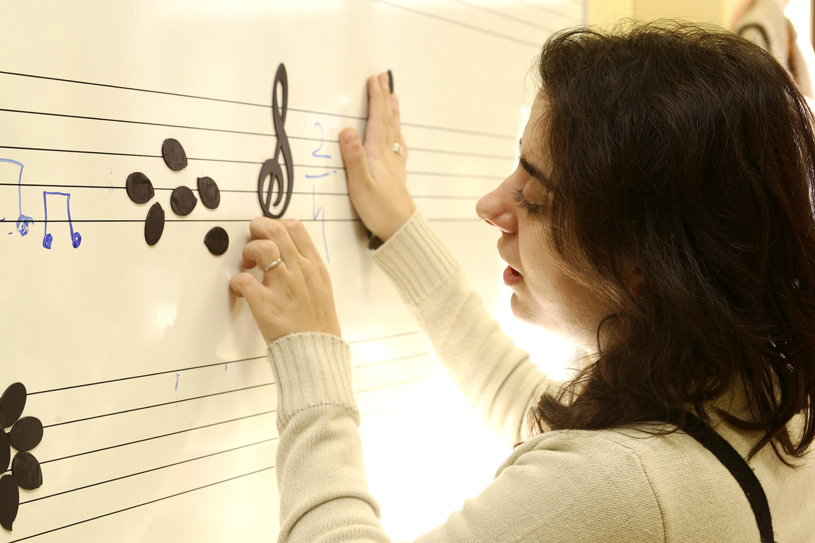 Maestra manipulando un pentagrama accesible