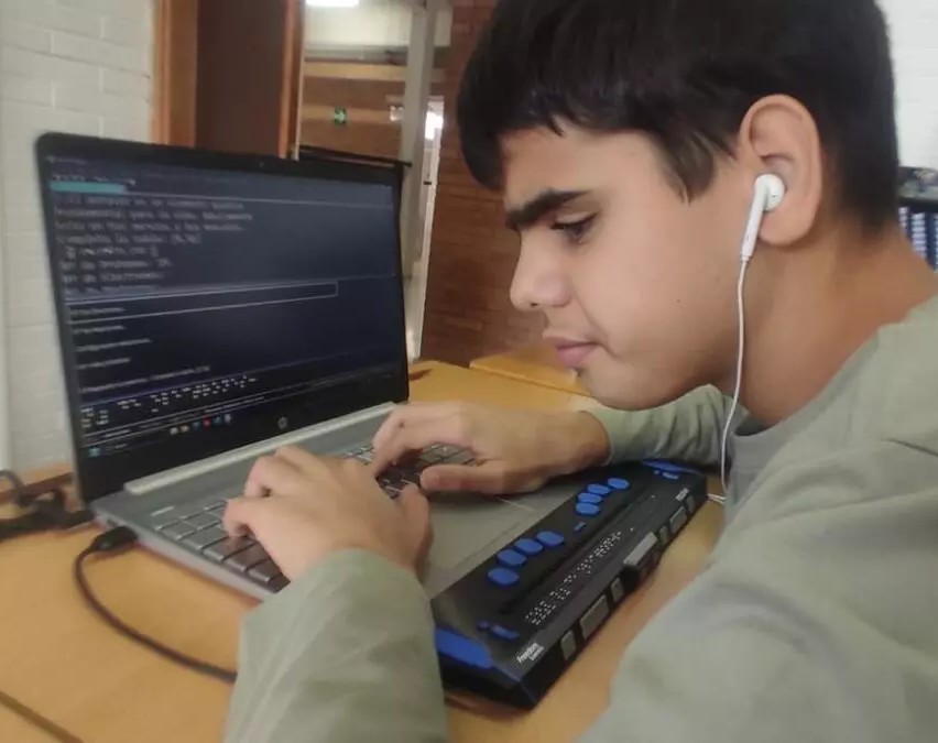 Pablo con ordenador y linea braille trabajando
