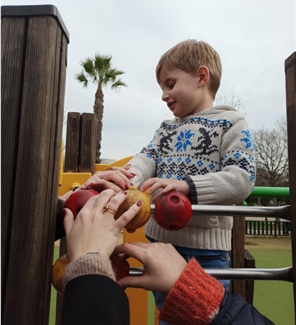 Alumno subido en una estructura del parque donde hay un tobogán y un puente