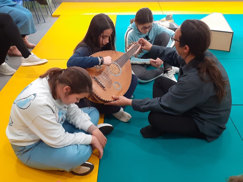 Alumnos tocando un instrumento de la India