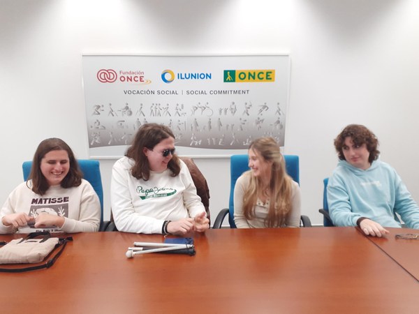 dos chicos y dos chicas sentados en una mesa y compartiendo opiniones 