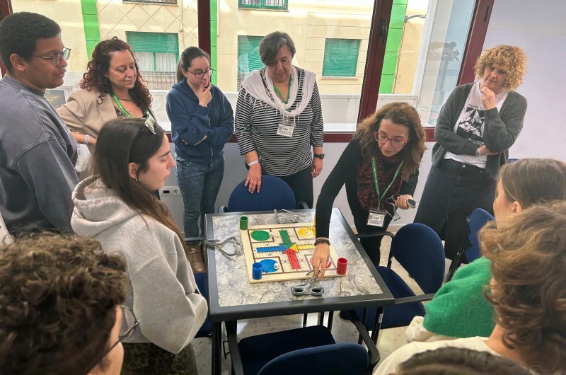 GRUPO DE ESTUDIANTES CON UN PARCHÍS ADAPTADO