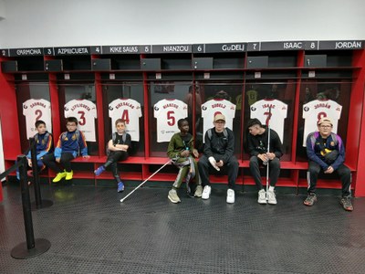 GRUPO DE ALUMNOS SENTADOS EN EL VESTUARIO DEL ESTADIO DEL SEVILLA