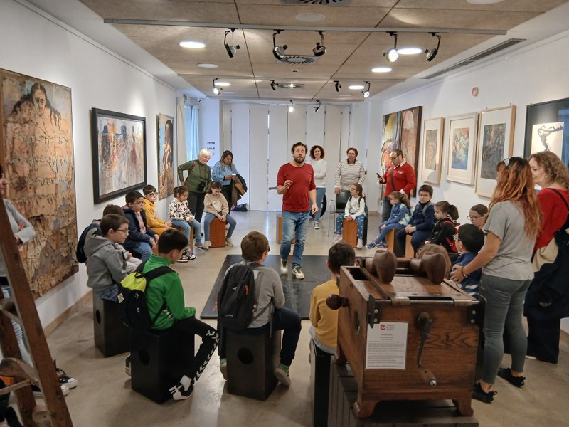 Monitor de percusión enseñando a una alumna a colocar las manos en el cajón flamenco.
