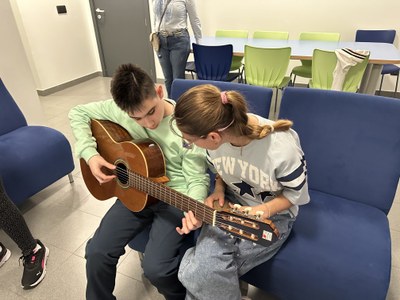 Chico y chica tocando la guitarra.