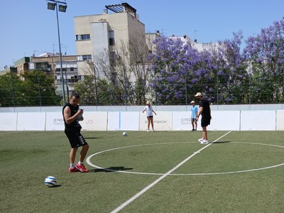 Un chico y una chica jugando a fútbol junto a dos entenadores
