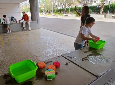 DOS ALUMNOS DISFRUTANDO CON UNO DE LOS JUEGOS DE AGUA
