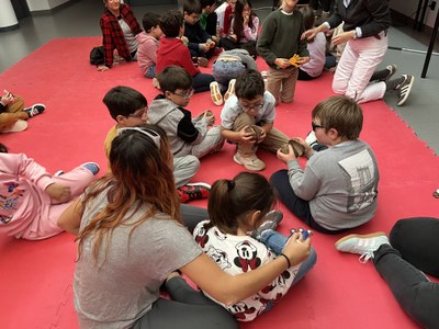 Alumnos en el cuentacuentos musical, tocando unos cocos imitando el sonido del trote del caballo.
