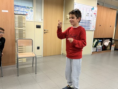 Alumno en el taller de LSE, expresando su nombre en dactilológico