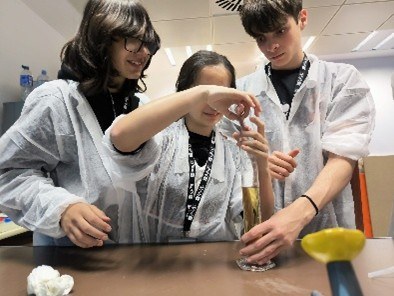 3 alumnos utilizando un tubo de ensayo