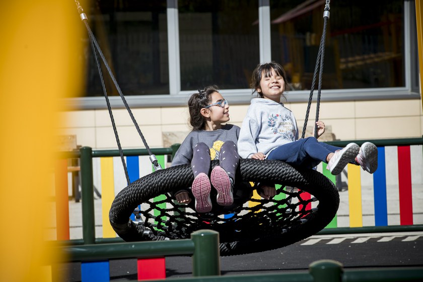 un niño y una niña jugando en un columpio