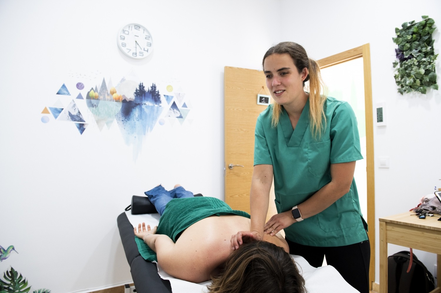 Fisioterapeuta en consulta realizando un masaje a una paciente