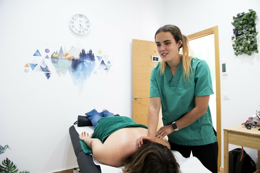 Fisioterapeuta en consulta realizando un masaje a una paciente