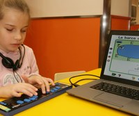 Niña manejando la linea braille con BRAITICO