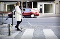 Mujer con bastón cruzando paso de cebra.