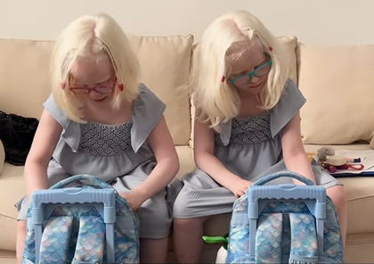 Dos niñas metiendo material escolar en su mochila