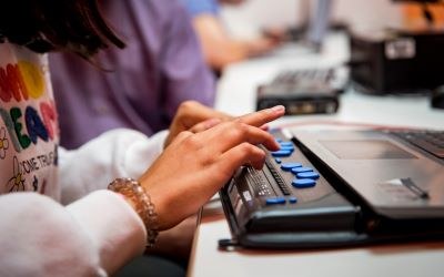 Niña escribiendo con la linea brauille