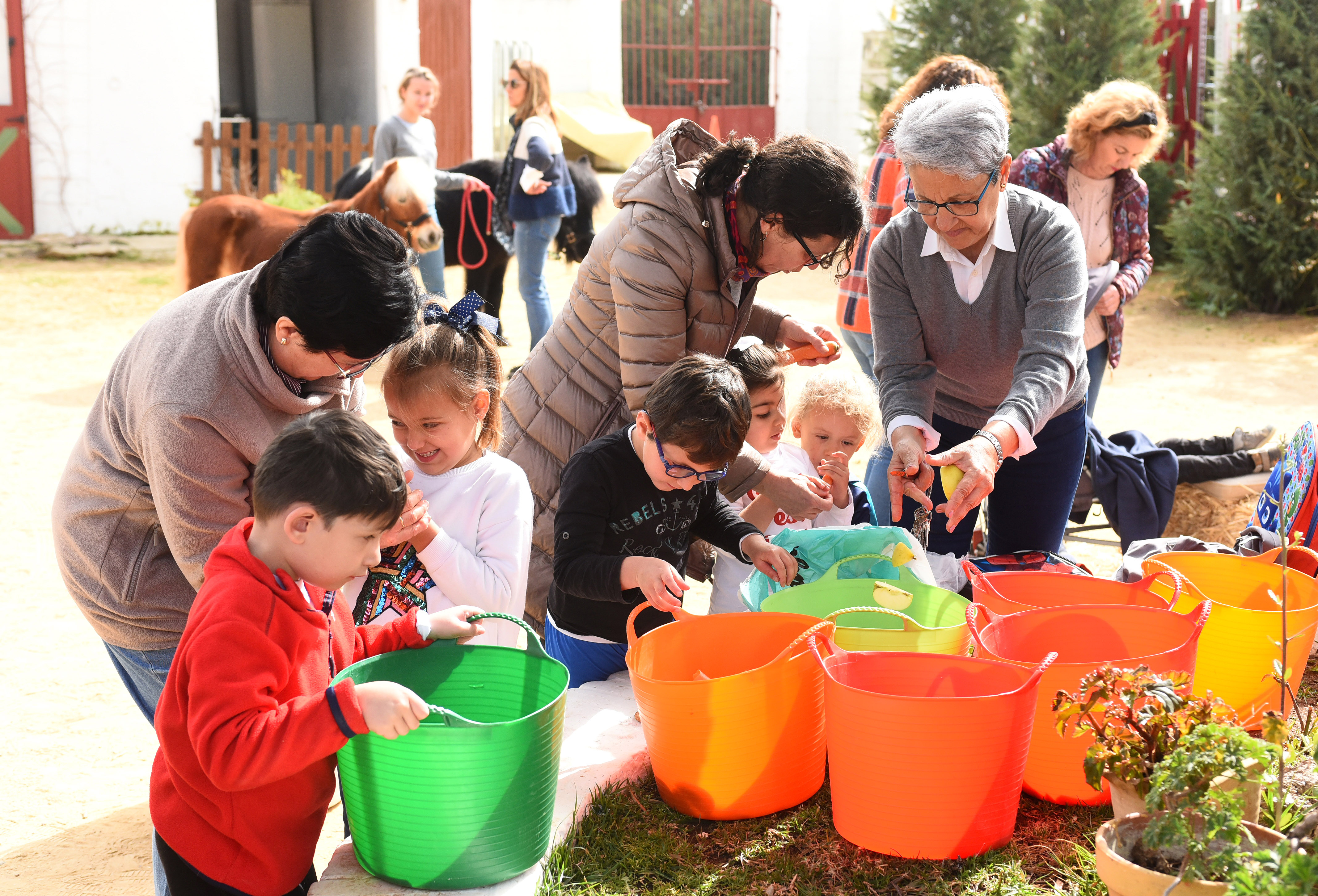 Taller en familia donde se están manipulando hojas en un entorno al aire libre Taller en familia donde se están manipulando hojas en un entorno al aire libre