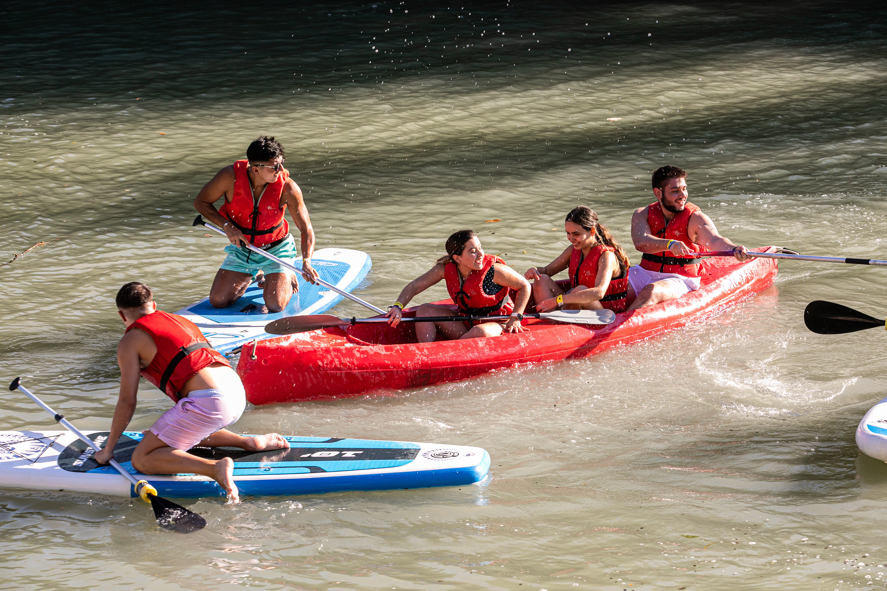 Grupo adolescentes realizando una actividad de kayak en el río